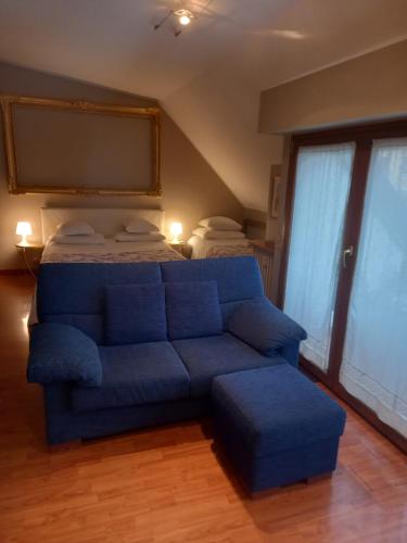 a blue couch and a bed in a room at Navigli Junior Suite - Quiet & comfy vintage Junior Suite with cozy balcony - 5th attic floor lift to 4th floor - metro' verde -green subway Porta Genova in Milan