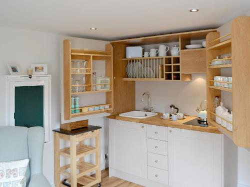 a kitchen with white cabinets and a sink at Little Willows in Bradenham