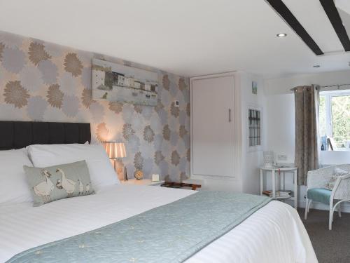 a bedroom with a large white bed and a window at Little Willows in Bradenham