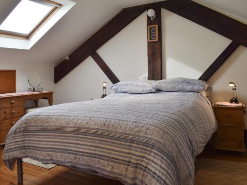 a bedroom with a large bed in a attic at Biskey Howe Cottage in Bowness-on-Windermere