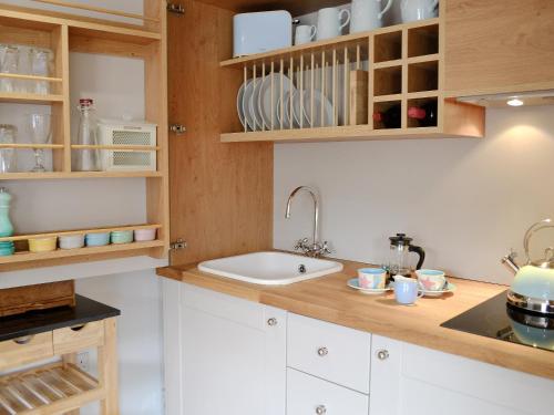 a kitchen with white cabinets and a sink at Little Willows in Bradenham