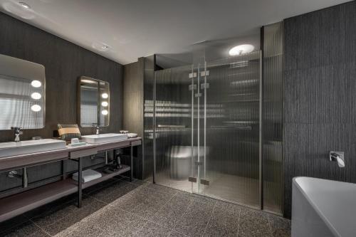 a bathroom with two sinks and a glass shower at TAI Urban Resort in Kaohsiung