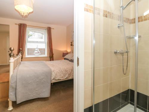 a bathroom with a shower and a bed in a room at Beach View in Benllech
