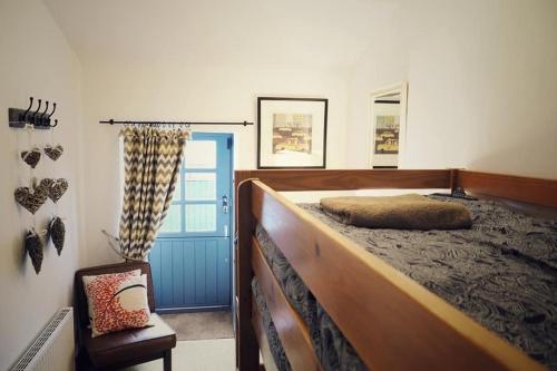um quarto com uma cama grande e uma porta azul em Woodworth Cottage em Barnoldswick