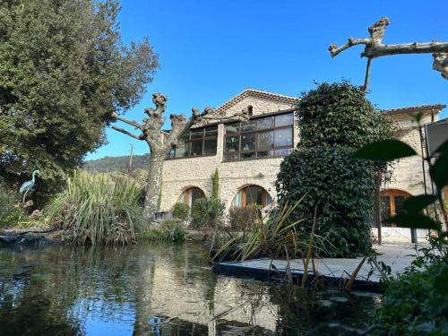 una casa con un laghetto davanti di Le Mas di Ro a Saint-Martin-dʼArdèche