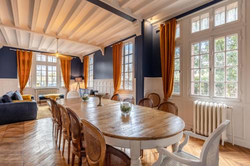 uma sala de jantar com uma mesa de madeira e cadeiras em Le Manoir des EMBRUNS 14P - Location N1- Terrace- public parking 2 min em Honfleur