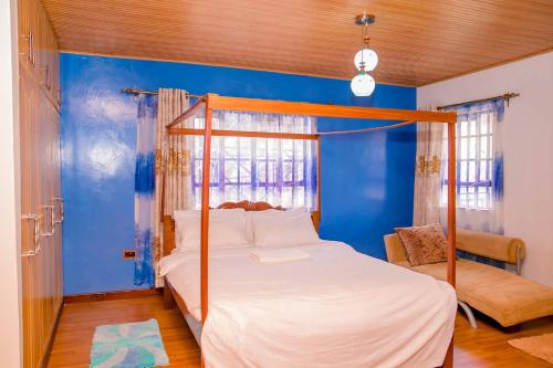 1 dormitorio con cama y pared azul en Hope Homestay, en Syokimau
