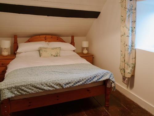 a bedroom with a bed with a wooden headboard at Dyserth in Clynnog-fawr