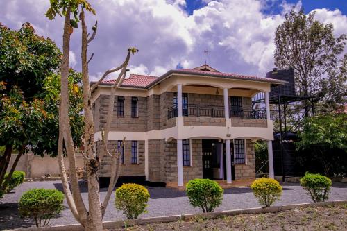 an old brick house with a balcony on top at Hope Homestay in Syokimau