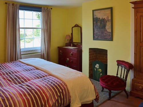 Fordwich的住宿－Bow Cottage，一间卧室配有一张床、镜子和椅子