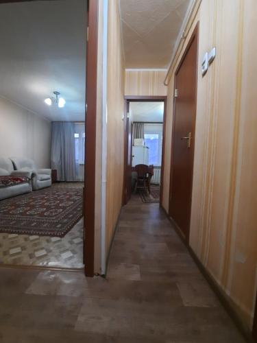 a hallway leading to a living room with a door at Однокомнатная Встреча in Astana