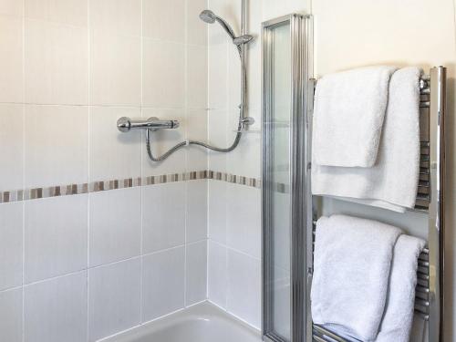 a bathroom with a shower and a bath tub at Garden Cottage in Hasfield