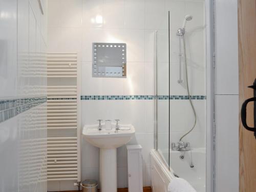 峰區森林的住宿－森林景觀度假屋，白色的浴室设有水槽和淋浴。