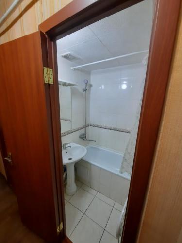 a bathroom with a bath tub and a sink at Однокомнатная Встреча in Astana