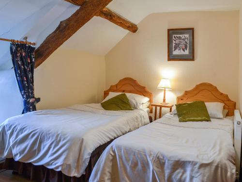 a bedroom with two beds and a window at Hen Hafod in Llanfor