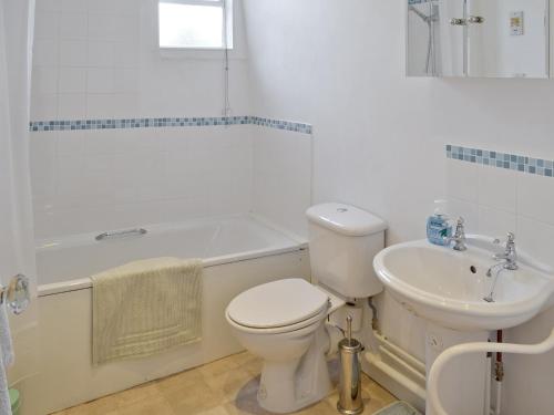 een badkamer met een toilet, een wastafel en een bad bij Red Lion Corner in Lavenham