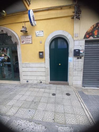 una porta verde sul lato di un edificio di casa vacanza con balcone a Laterza