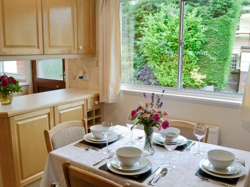 a kitchen with a table with a vase of flowers on it at Bydand in Walkerburn