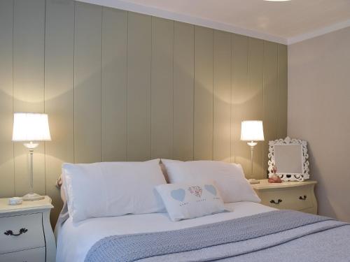 una camera con un letto con due lampade e uno specchio di Seatrees a Corton
