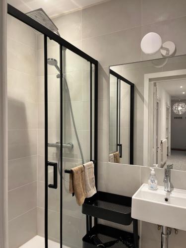 y baño con ducha, lavabo y espejo. en Appartement Oliver, en Chamonix-Mont-Blanc