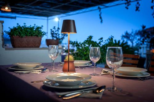 a table with plates and wine glasses on it at Pansion Marjan in Zavala