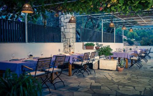 a group of tables and chairs with purple table cloth at Pansion Marjan in Zavala