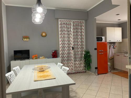 una cucina con tavolo, sedie e frigorifero di “L’ Angolo dei Sogni” Apartment a Casale Monferrato