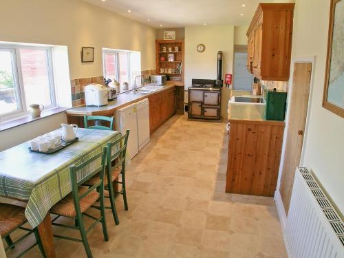 een grote keuken met een tafel en stoelen. bij Purcombe Farmhouse - 28458 in Whitchurch Canonicorum