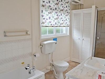 a bathroom with a toilet and a sink and a window at Levans Cottage in Lindale