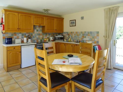 a kitchen with a wooden table and chairs in it at Meadow View in Leiston