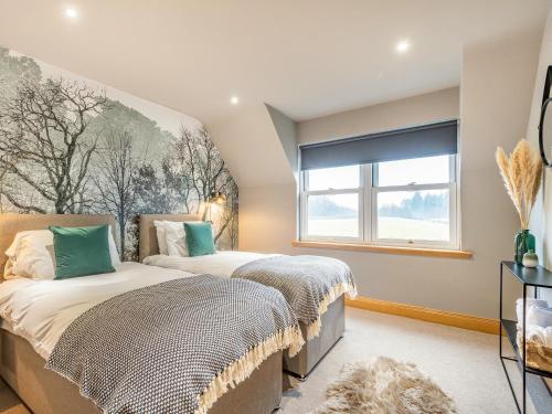 two beds in a bedroom with a window at Hill View in Dalbeattie