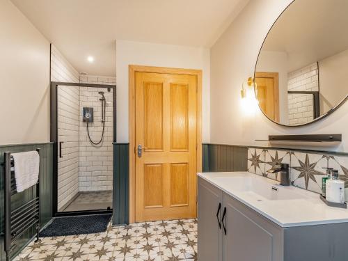 a bathroom with a sink and a shower and a mirror at Hill View in Dalbeattie