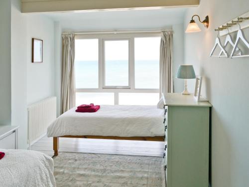 a bedroom with a bed and a window at Turnstone Cottage in Sheringham