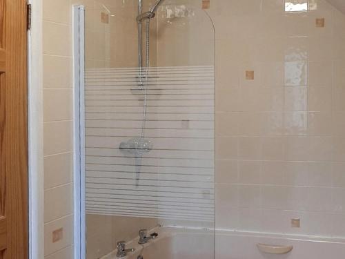 a bathroom with a shower and a bath tub at Forge Cottage - 28221 in Shaldon