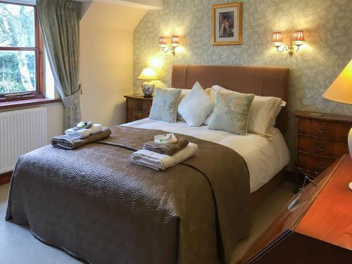 a bedroom with a large bed with towels on it at Russet Cottage in Moreton in Marsh