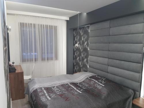 una camera con un grande letto con testiera grigia di Ekskluzywny Apartament Krynica - Zdrój a Krynica-Zdrój