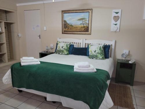 una camera da letto con un grande letto con asciugamani di De Heide Guesthouse a Bothaville