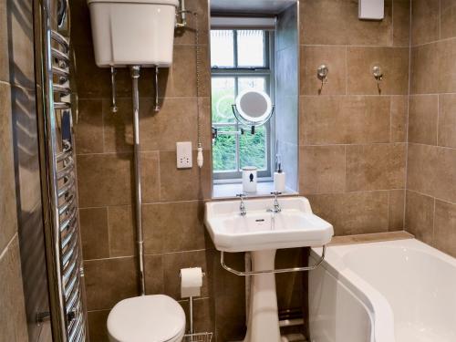 a bathroom with a sink and a toilet and a tub at Whatley Lodge in Winsham