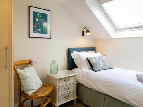 a bedroom with a bed and a chair and a window at Abbeygate House in York