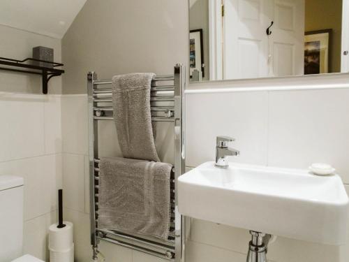 a white bathroom with a sink and a mirror at Abbeygate House in York