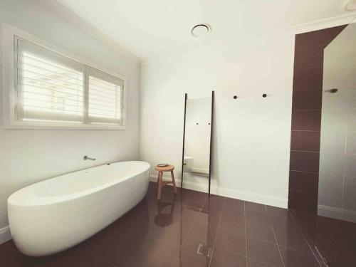 a bathroom with a large white tub and a window at The York Residence in Hartley NSW - Newly Listed in Hartley