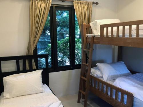 two bunk beds in a room with a window at Villa Seaview Garden in Ko Tao