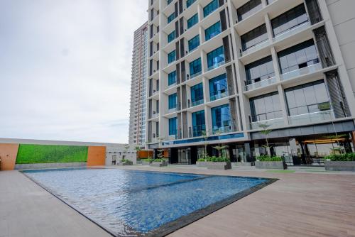 a swimming pool in front of a building at EMKA Lodge studio room the vertu apartemen ciputra world surabaya in Surabaya