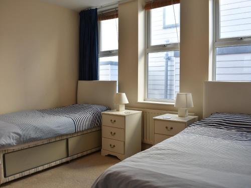 a bedroom with two beds and two windows at Pinecliffe Avenue in Southbourne