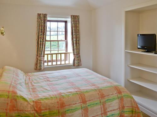 1 dormitorio con cama y ventana en Diggers Cottage, en Oxton