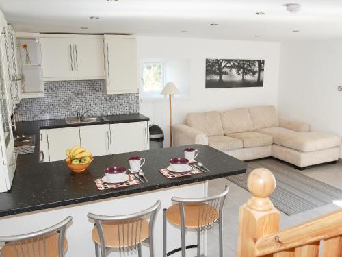 a kitchen and living room with a table and chairs at Chestnut Cottage in Knitsley