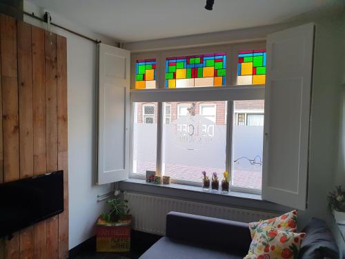 a window with a rainbow colored stained glass at B&B de Loeff in Waalwijk