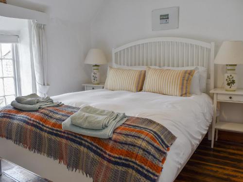 a bedroom with a white bed with a blanket on it at Herston Rise in Swanage