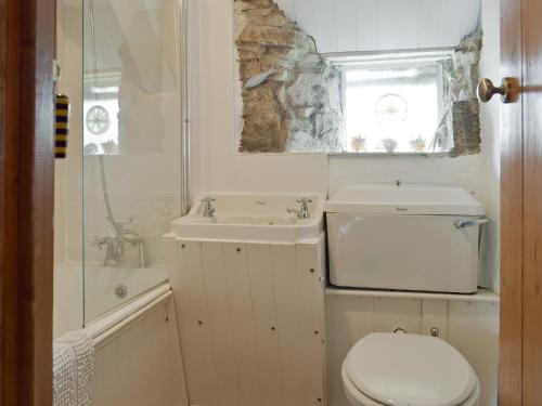 a white bathroom with a toilet and a sink at Herston Rise in Swanage