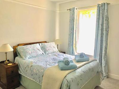 a bedroom with a bed with blue towels on it at Ivy Cottage in Skipton